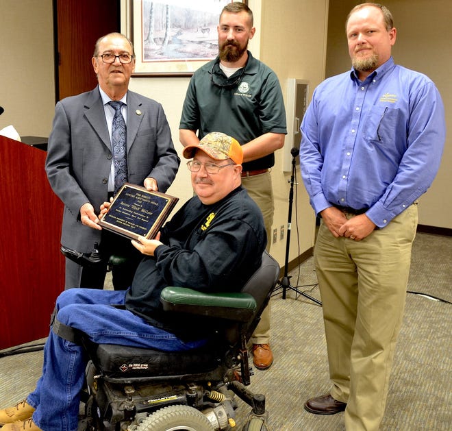 Thad Bellow (center) accepts the Todd Roberts Achievement Award from LDWF Secretary Jack Montoucet (left), LDWF Biologist Educator Supervisor Brad Jackson (center standing) and Hunter Education Program Manager Eric Shanks (right)