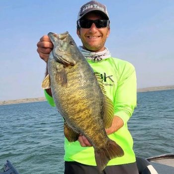 Troy Diede holds a seven pound, 4.7 ounce smallmouth bass he caught on Lake Oahe. Diede caught the record-breaking fish on Friday, July 16.