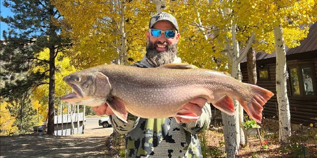 Matt Smiley, an angler from Lake City, Colorado, holds up his record-breaking brook trout, which he caught from Waterdog Lake on Oct. 8, 2022.